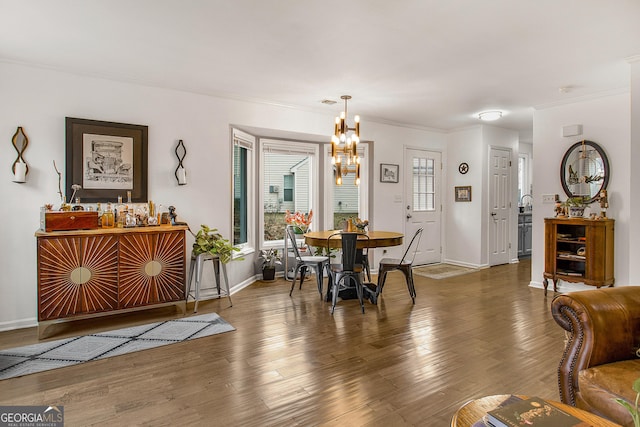 dining area with dark hardwood / wood-style flooring, crown molding, and a chandelier