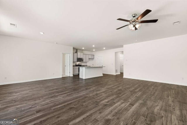 unfurnished living room featuring ceiling fan and dark wood-type flooring