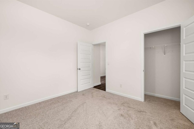 unfurnished bedroom featuring carpet flooring and a closet