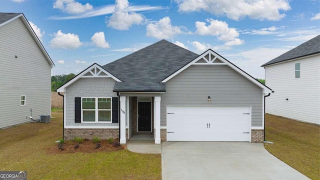 craftsman-style home featuring a front yard, a garage, and cooling unit