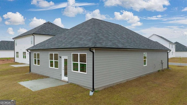 back of property featuring a lawn and a patio