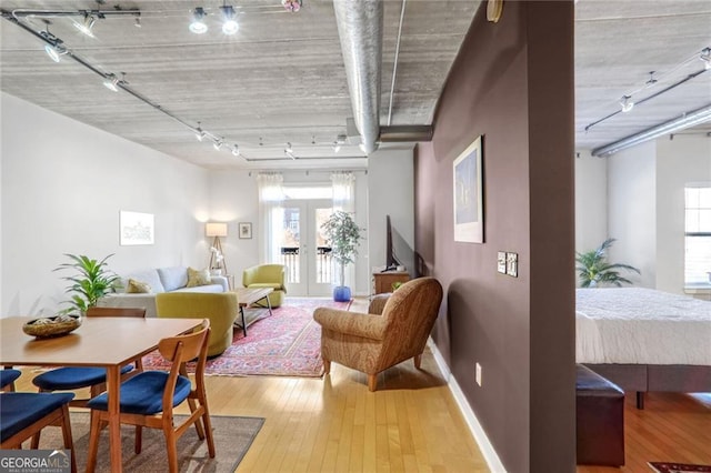 interior space with wood-type flooring, rail lighting, and french doors