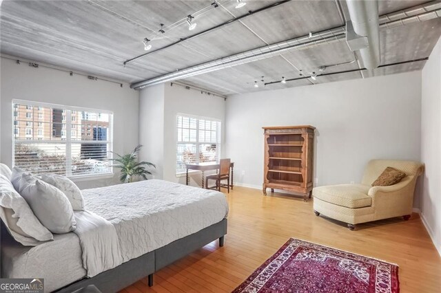 bedroom featuring wood-type flooring and track lighting