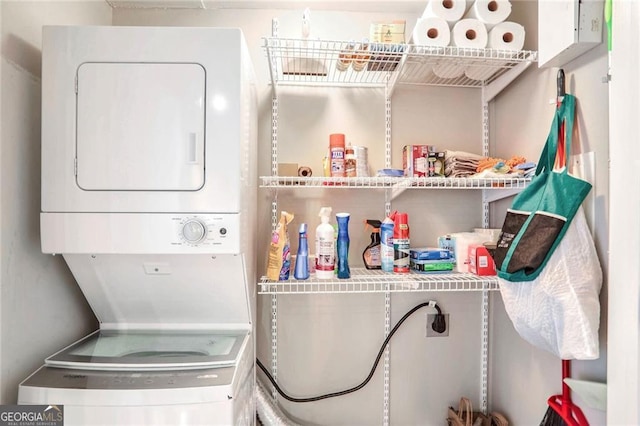 washroom featuring stacked washer and clothes dryer