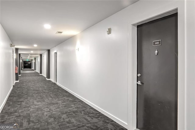 corridor with dark colored carpet