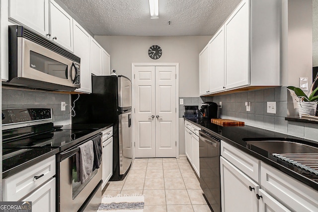 kitchen with white cabinets, kitchen peninsula, a textured ceiling, and stainless steel fridge