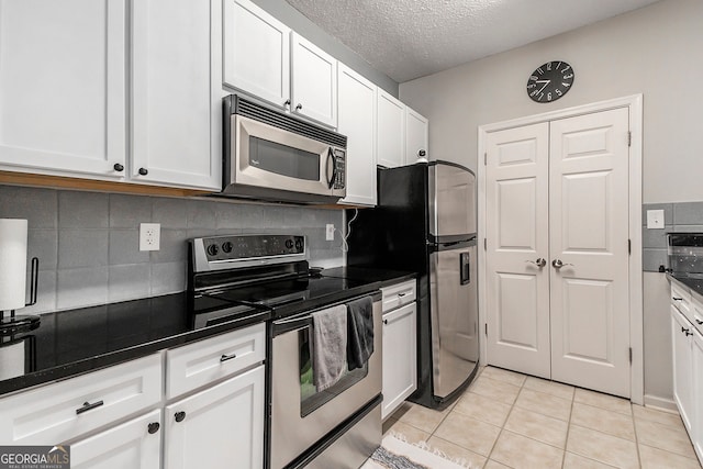 kitchen featuring white cabinetry, a notable chandelier, kitchen peninsula, and stainless steel appliances