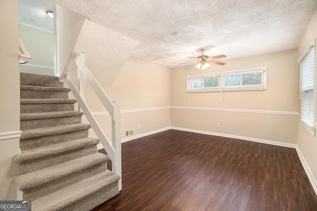 staircase featuring hardwood / wood-style floors, a textured ceiling, and ceiling fan