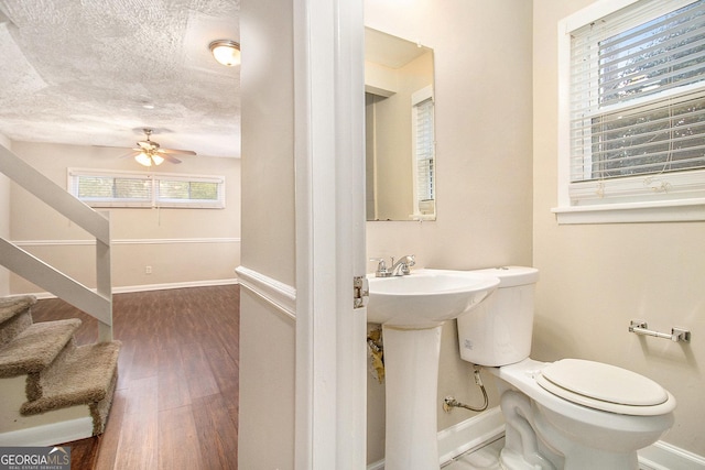 bathroom with hardwood / wood-style flooring, ceiling fan, toilet, and sink