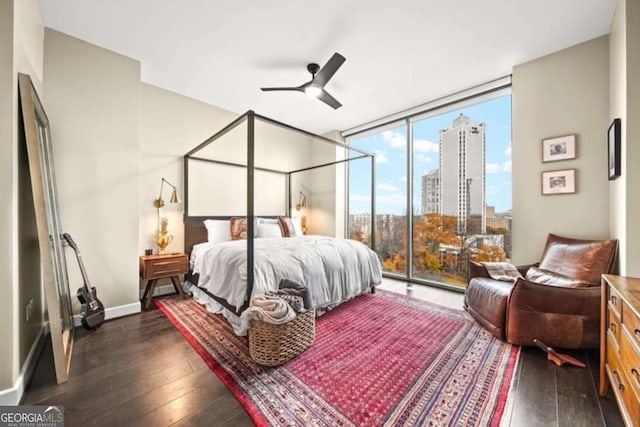 bedroom with access to exterior, ceiling fan, expansive windows, and dark hardwood / wood-style flooring