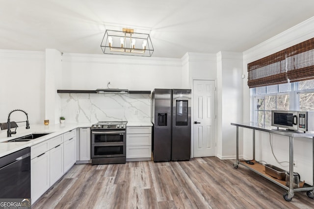 kitchen with sink, ventilation hood, backsplash, appliances with stainless steel finishes, and hardwood / wood-style flooring