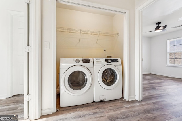 washroom featuring washing machine and dryer, ceiling fan, and wood-type flooring