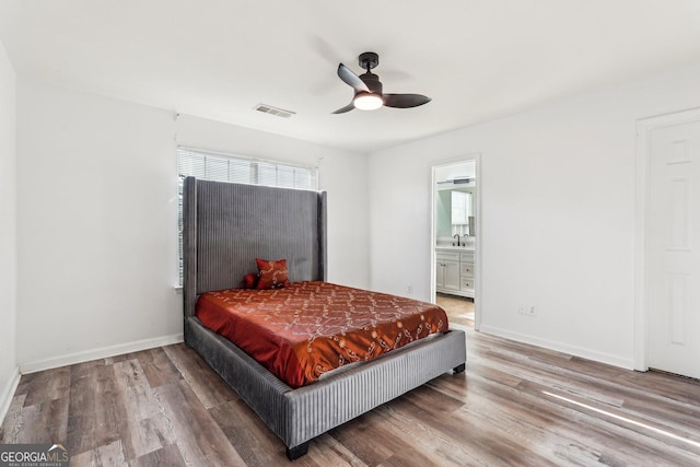 bedroom with ceiling fan, wood-type flooring, sink, and ensuite bath