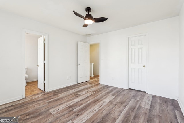 unfurnished bedroom with ensuite bathroom, a closet, ceiling fan, and light wood-type flooring