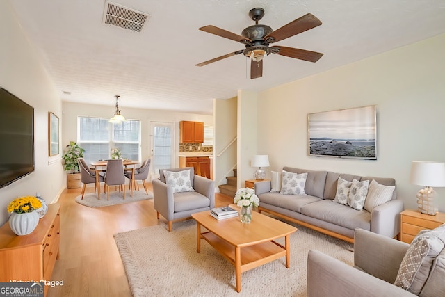 living room with ceiling fan and light hardwood / wood-style flooring