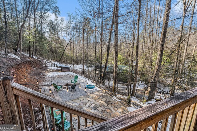 snow covered deck featuring an outdoor fire pit