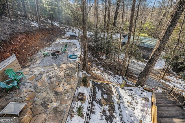 yard layered in snow featuring a patio area and an outdoor fire pit