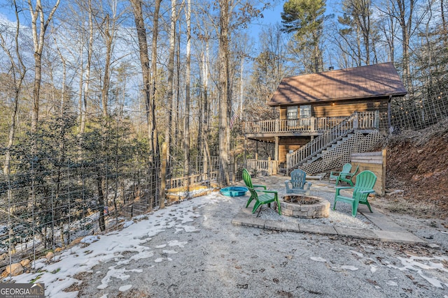 snow covered patio with a deck and a fire pit