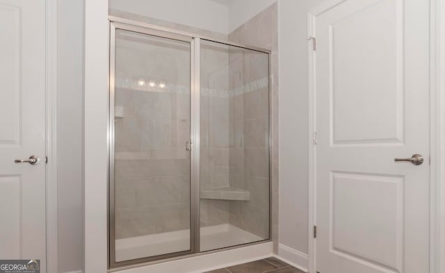 bathroom featuring tile patterned flooring and a shower with shower door