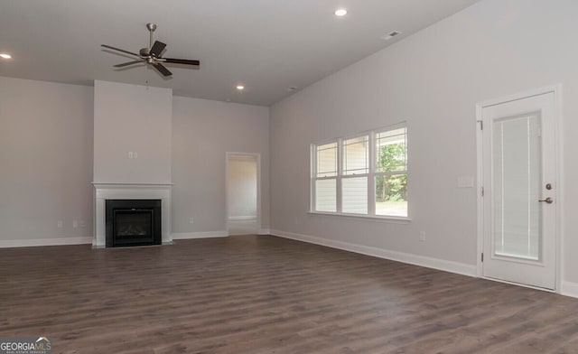 unfurnished living room with ceiling fan, dark hardwood / wood-style flooring, and a high ceiling