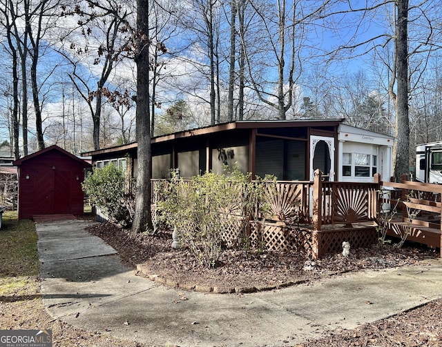 single story home with a wooden deck and a shed