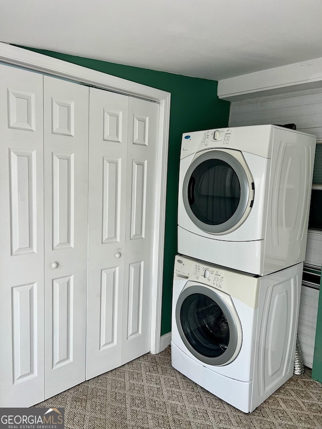 clothes washing area with stacked washer and clothes dryer