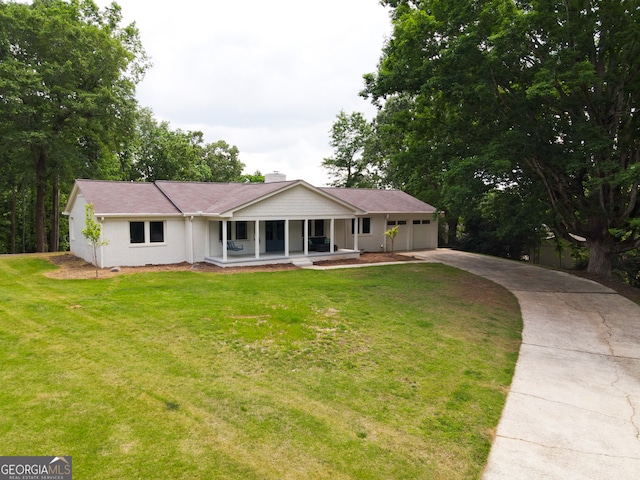 single story home with a front lawn, covered porch, and a garage