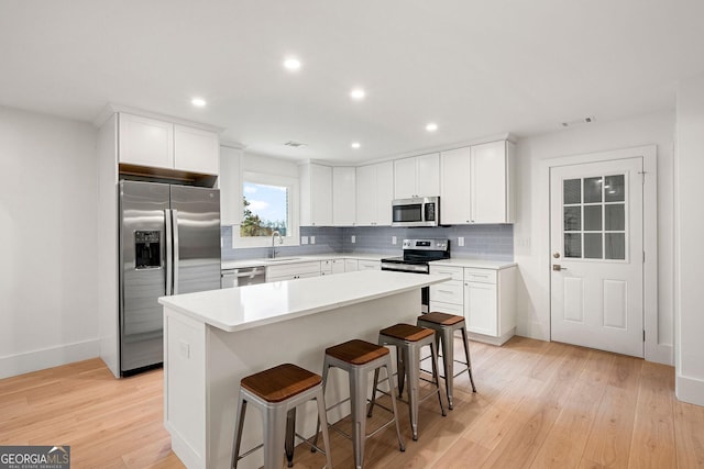 kitchen featuring white cabinets, a kitchen island, and appliances with stainless steel finishes