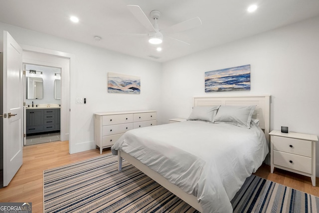 bedroom with ceiling fan, light wood-type flooring, and ensuite bath