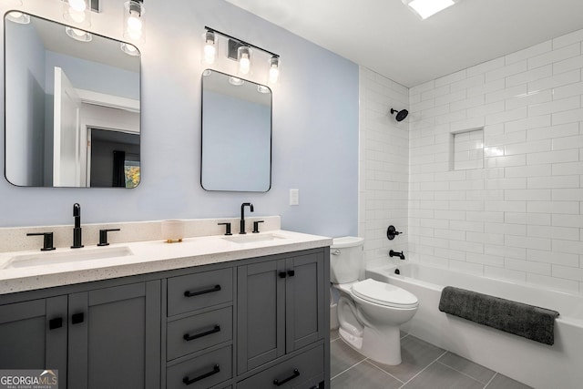 full bathroom with toilet, tile patterned flooring, vanity, and tiled shower / bath