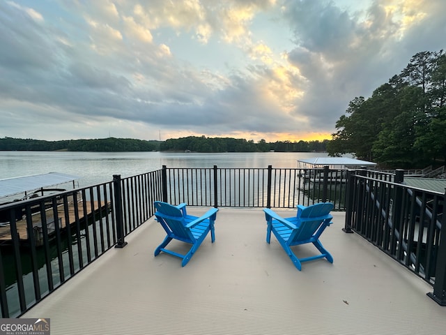 patio terrace at dusk featuring a water view