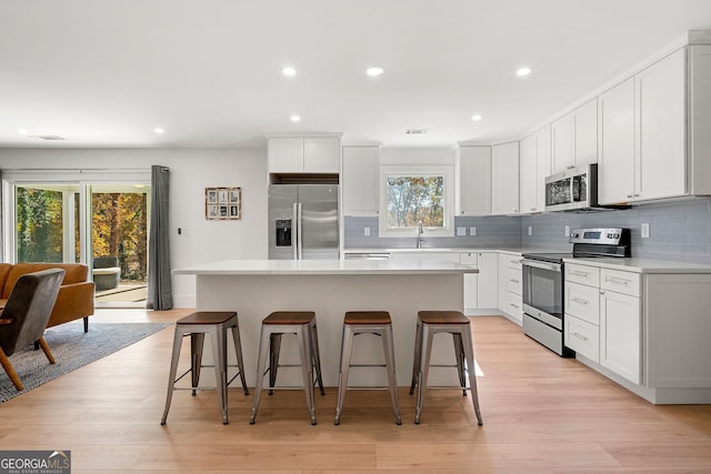 kitchen with a center island, stainless steel appliances, and plenty of natural light