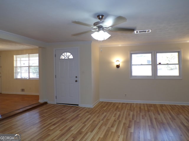 entryway featuring light hardwood / wood-style flooring, ornamental molding, and ceiling fan