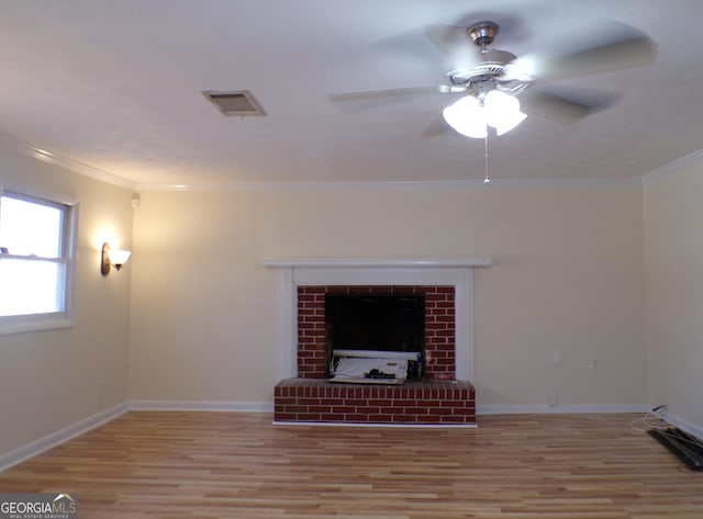 unfurnished living room featuring a brick fireplace, crown molding, and light hardwood / wood-style floors