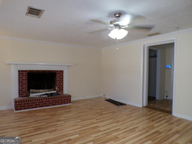 unfurnished living room featuring a fireplace, ornamental molding, and light wood-type flooring