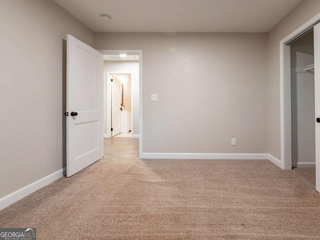 unfurnished bedroom with light carpet and a closet