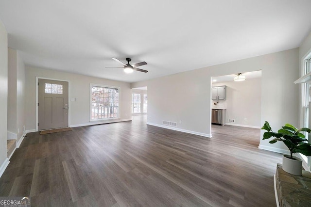 unfurnished living room featuring ceiling fan and dark hardwood / wood-style floors