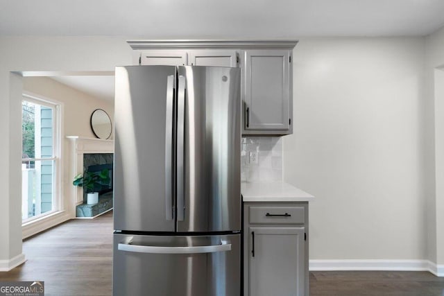 kitchen with hardwood / wood-style flooring, gray cabinetry, stainless steel refrigerator, and tasteful backsplash