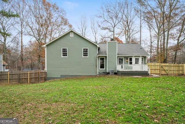 rear view of house featuring a lawn and a wooden deck