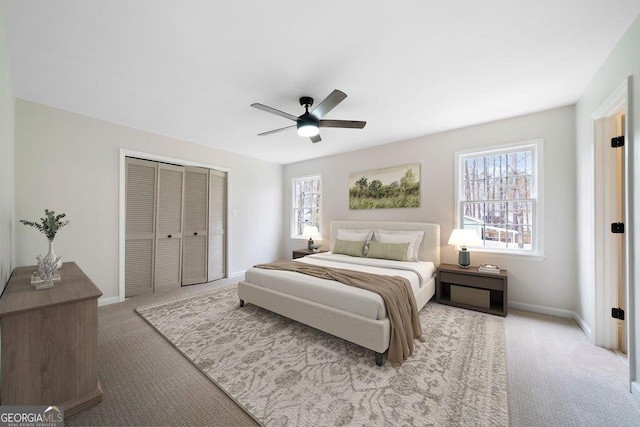 bedroom featuring ceiling fan, light colored carpet, and a closet