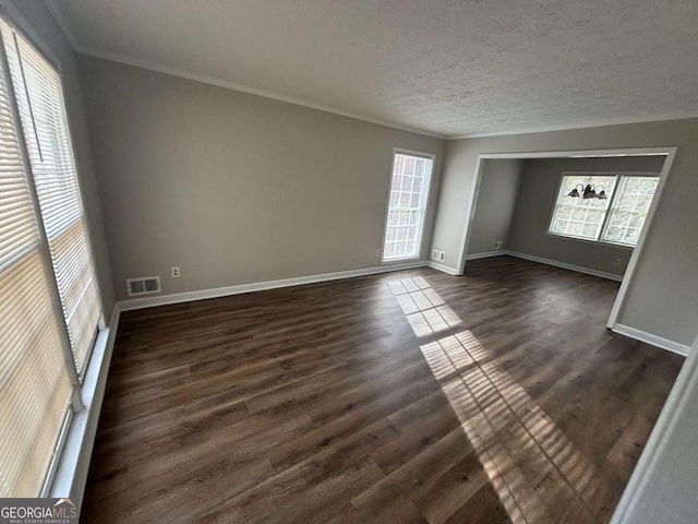 unfurnished room with a textured ceiling, dark hardwood / wood-style flooring, and crown molding