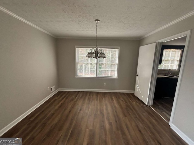 unfurnished dining area with a textured ceiling, crown molding, sink, a chandelier, and dark hardwood / wood-style floors