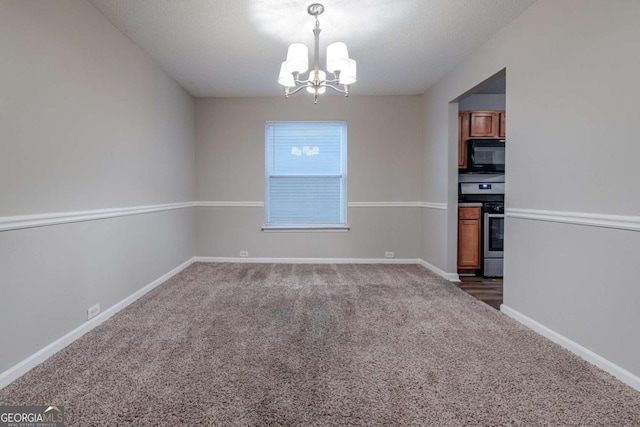 unfurnished dining area featuring dark carpet, a textured ceiling, and an inviting chandelier