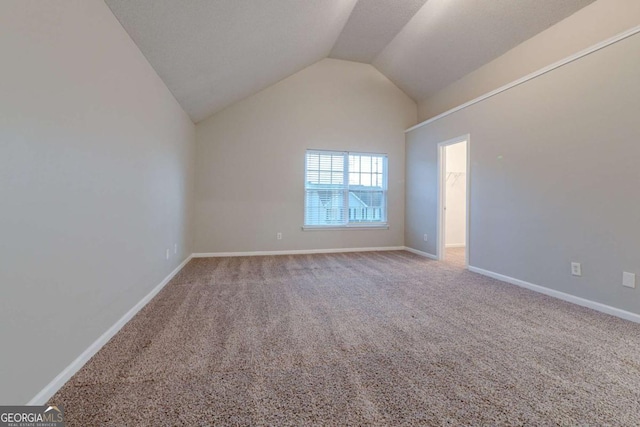 unfurnished room with carpet and vaulted ceiling