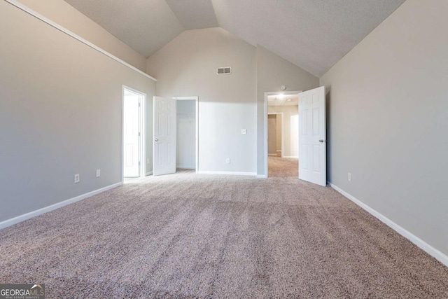 carpeted spare room featuring high vaulted ceiling