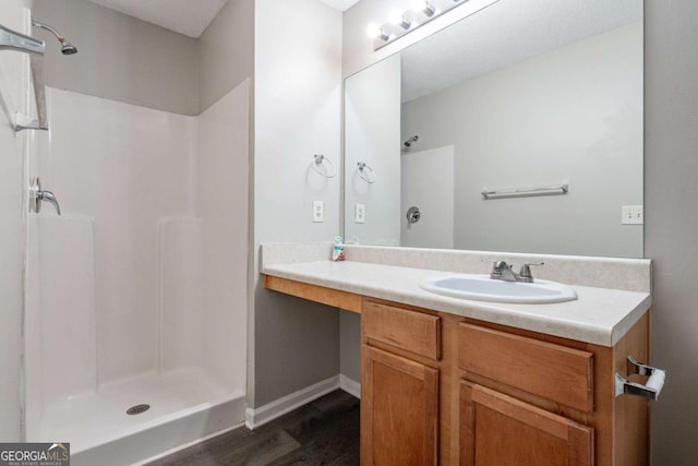 bathroom with vanity, a shower, and wood-type flooring