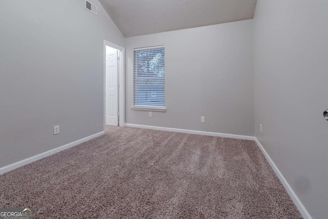 carpeted spare room with lofted ceiling and a textured ceiling