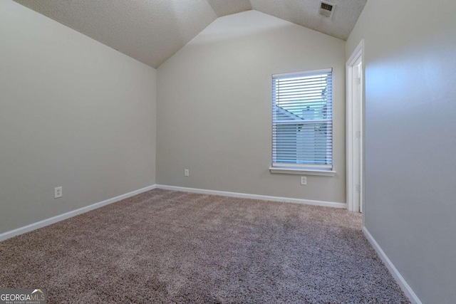 empty room with carpet, a textured ceiling, and vaulted ceiling