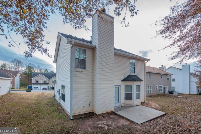 rear view of house with a yard and a patio