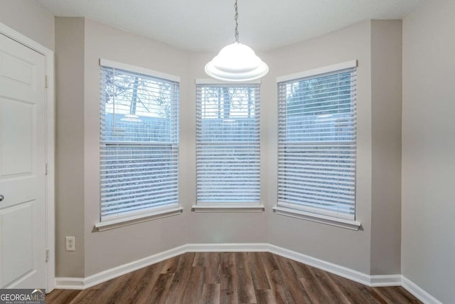 unfurnished dining area featuring dark hardwood / wood-style flooring